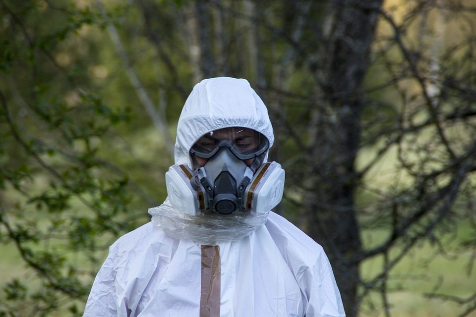 worker in protective clothing with respirator]
